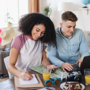 Young couple with laptop packing for holiday, coronavirus concept. Travel AI Assistant